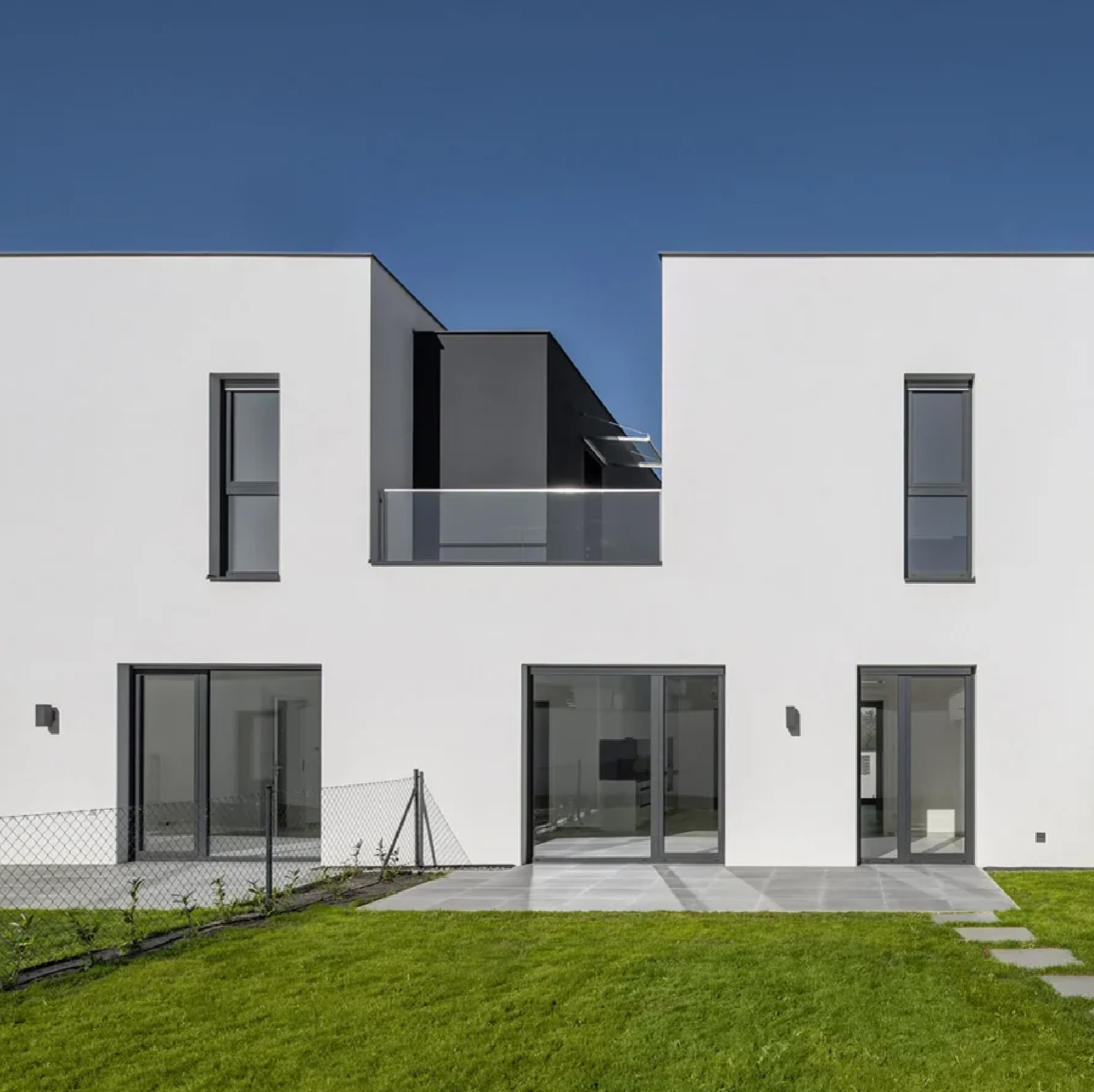 Contemporary row houses with white façades, large windows, private terraces, and landscaped outdoor spaces.