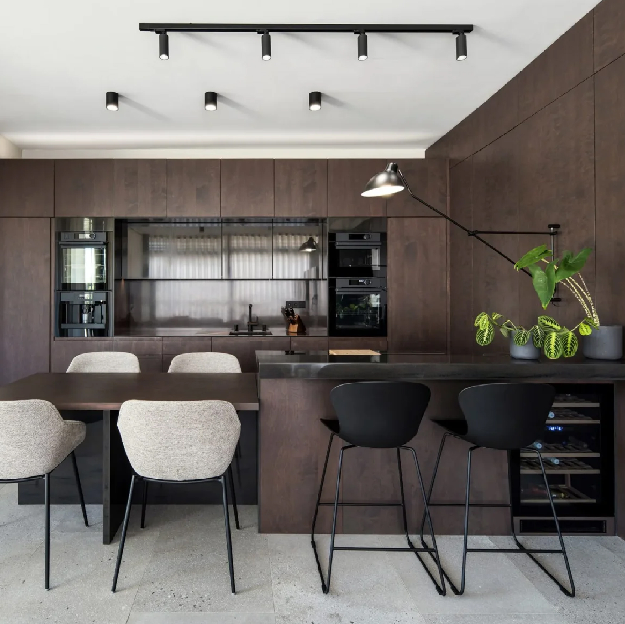 Contemporary kitchen with dark smoked oak cabinetry, black finishes, integrated appliances, and a central island.